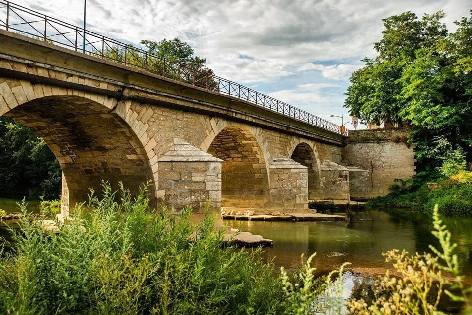 Pont de pierre à arches sur une rivière du Migennois